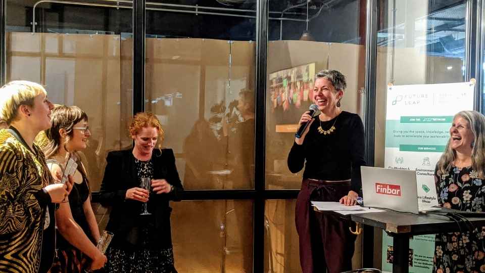HOLLY BROWNE (THIRD FROM LEFT), KATHERINE PIPER (SECOND FROM RIGHT) AND JENNY FOSTER (FAR RIGHT) (Global Goals Centre) laughing with the fashion show audience 