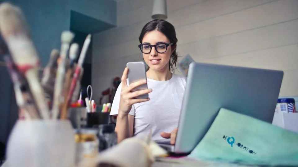 woman staring at phone in office.