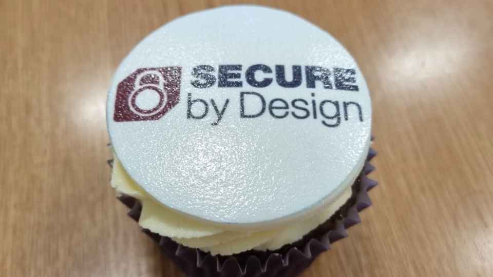 Cupcake with 'secure in design' on the icing