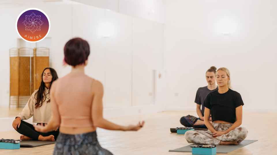 Group of people sat in yoga studio.