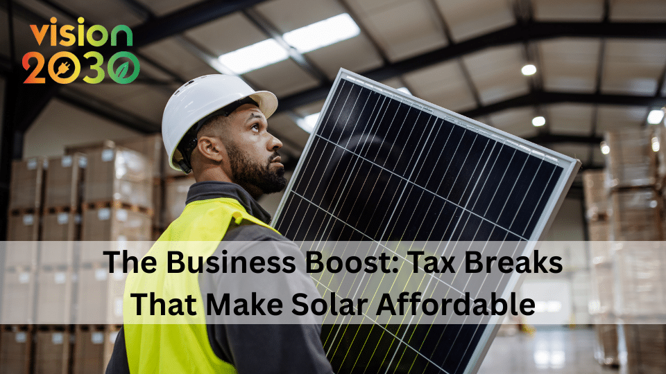 image of white man in helmet and high vis holding a soalr panel. text overlay says: The Business Boost: Tax Breaks That Make Solar Affordable