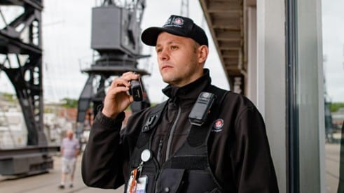 security guard contracted to Bristol City Council on Bristol Harbourside, white man in black security vest and clothing