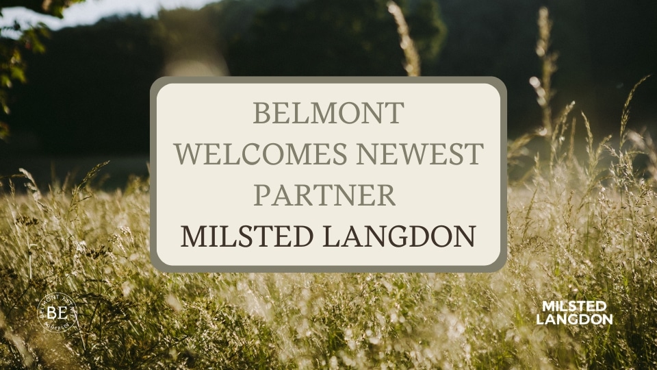 A field of tall grass and a sign which reads 'Belmont welcomes newest partner Milstead Langdon.'